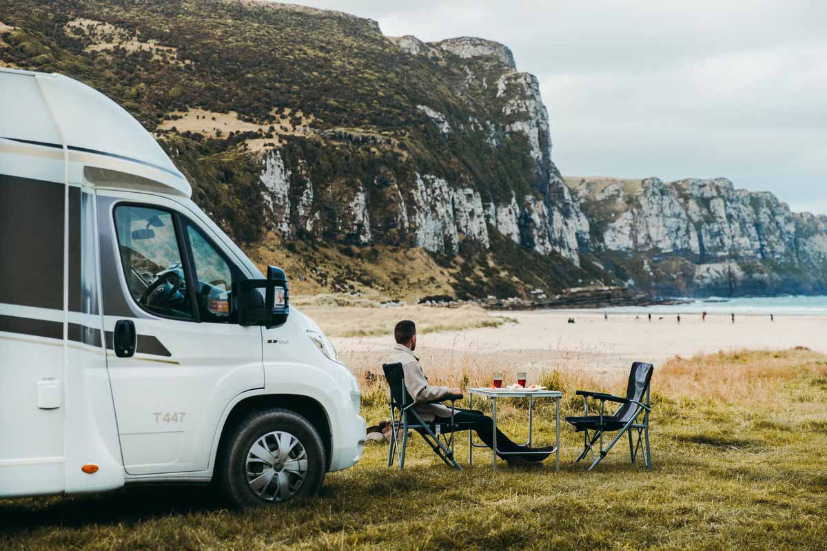 Eating outdoor beside motorhome facing a beach