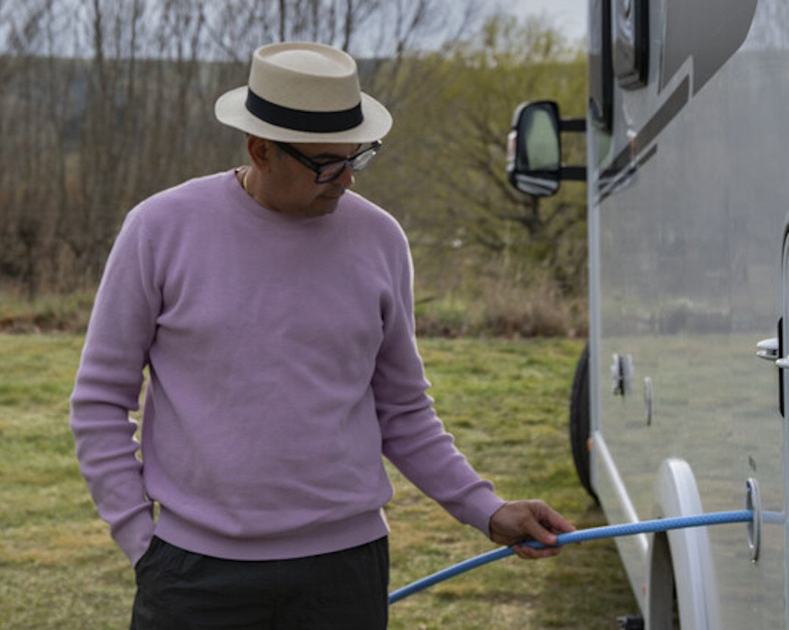 Man filling up a motorhome fresh water tank