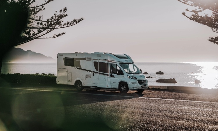 A Carado motorhome parked up beside a beach