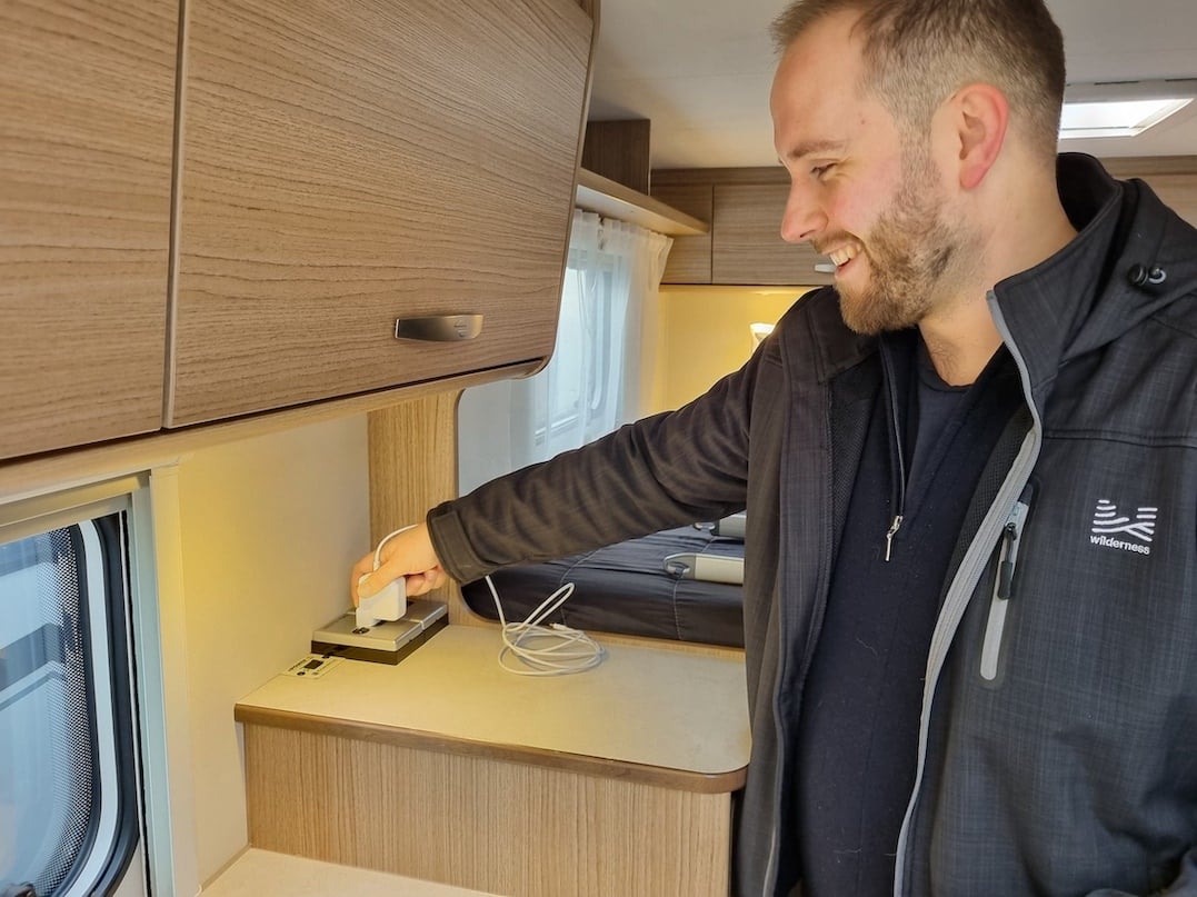 Person using an inverter plug inside a motorhome