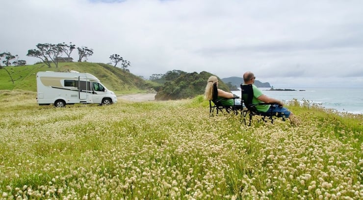 Freedom camping in the North Island by a beach in a field