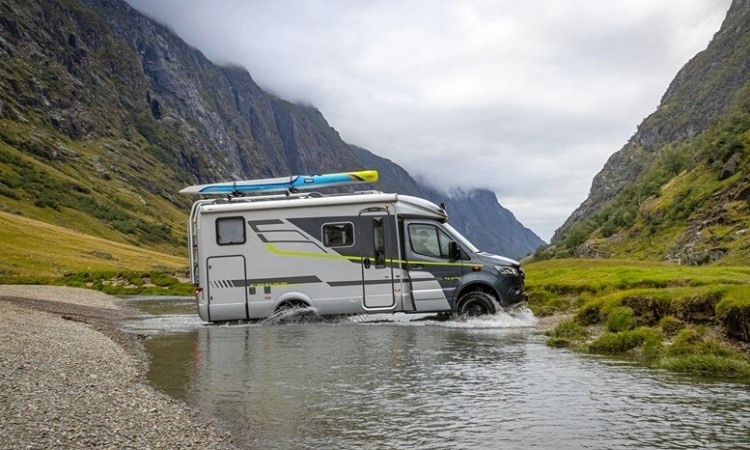 The HYMER CrossOver four wheel drive motorhome being driven through a river