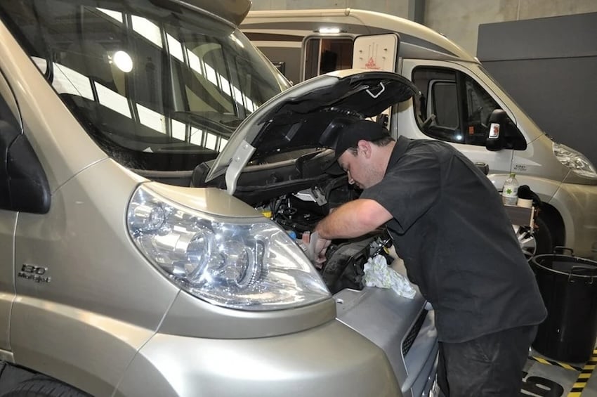 A mechanic inspecting motorhome fluids