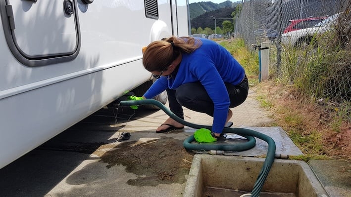 Woman draining her motorhome's grey water