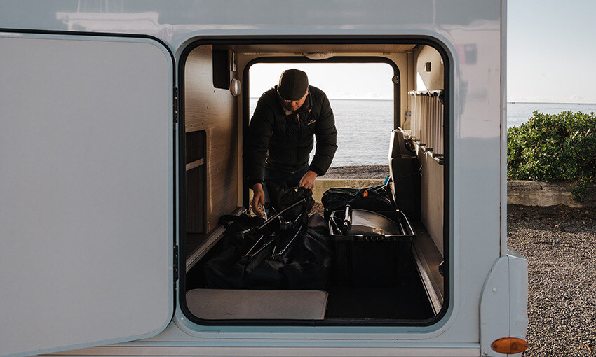 A man looking for stuff in his motorhome garage