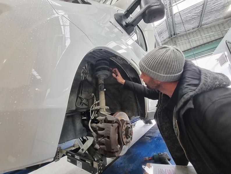 Mechanic inspecting a motorhome's suspension