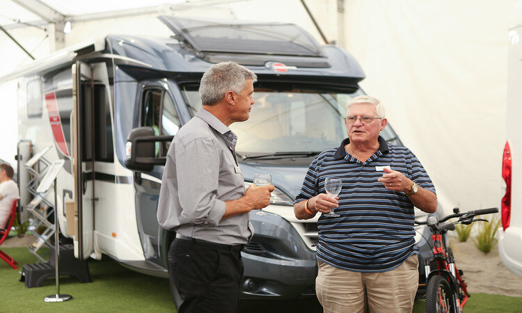 A potential motorhome buyer asking questions to a sales consultant at a motorhome show