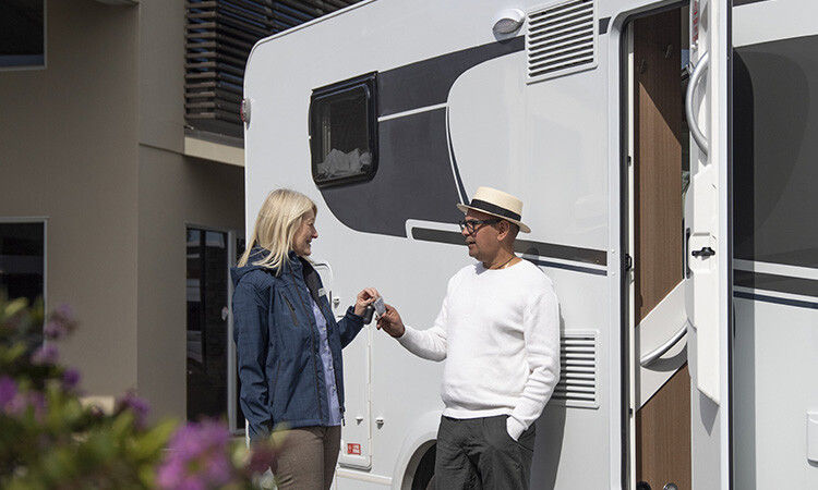 A buyer of a motorhome collecting keys from a motorhome salesperson