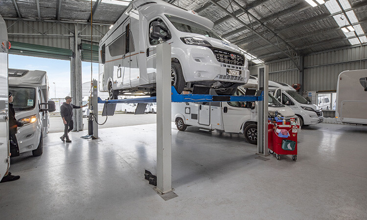 A motorhome being inspected in a workshop