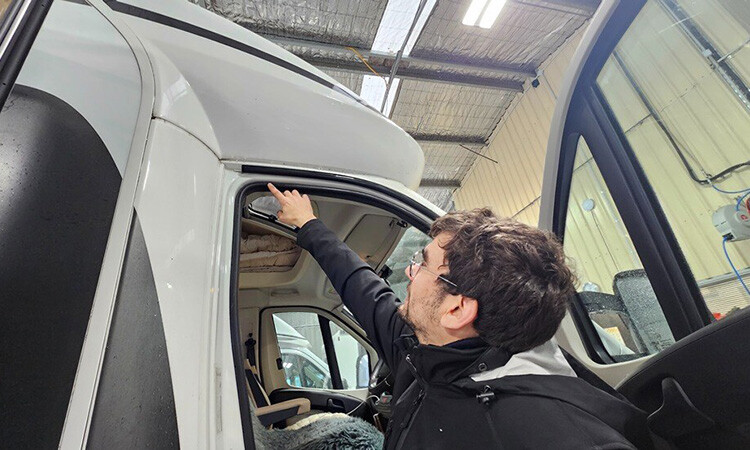 A technician inspecting the door seal of a motorhome