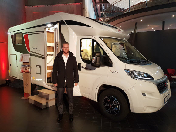 Josh Smith standing in front of a Bürstner Lyseo motorhome in Germany
